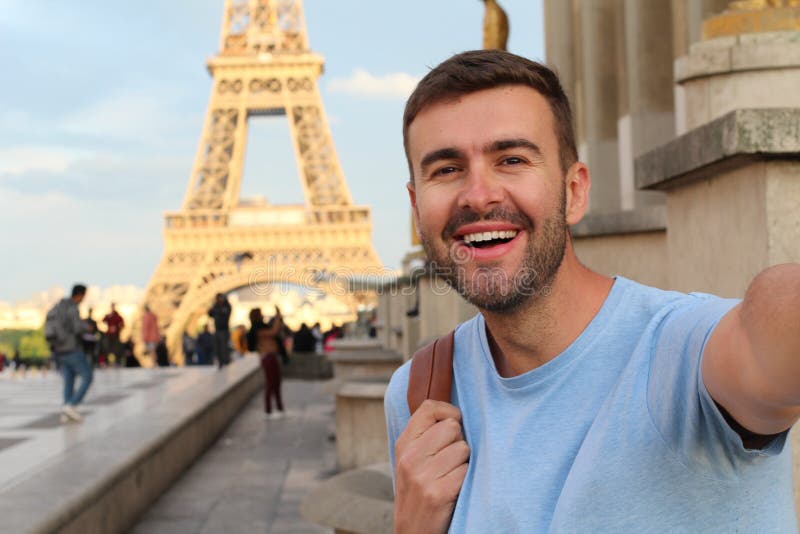 Young Man With Backpack Looking At Eiffel Tower In Paris Stock Photo