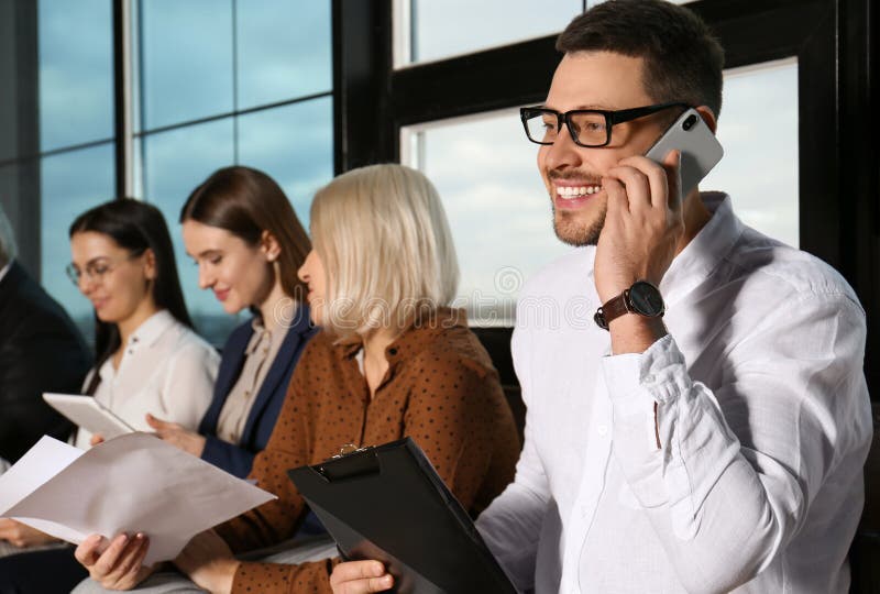 Man Talking on Phone while Waiting for Job Interview in Hall Stock