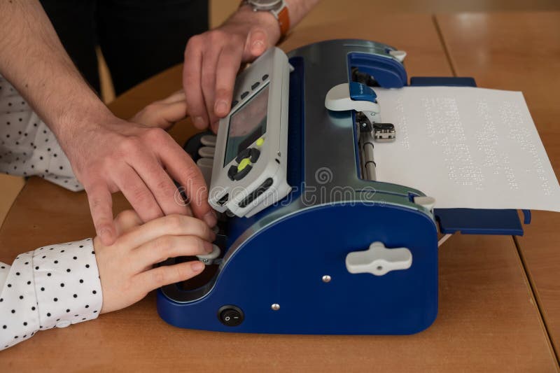 A Man Teaches a Blind Woman To Type on Braille Machine. Stock Photo