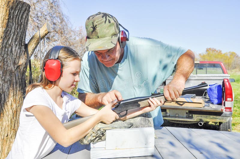 Man teaching teenage girl how to shoot