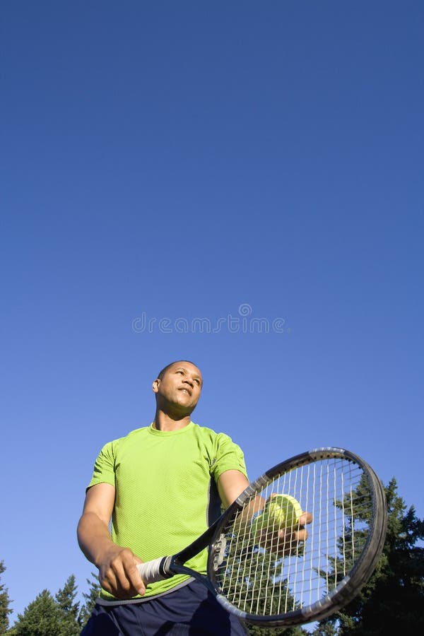 Man on Tennis Court Serving Tennis Ball