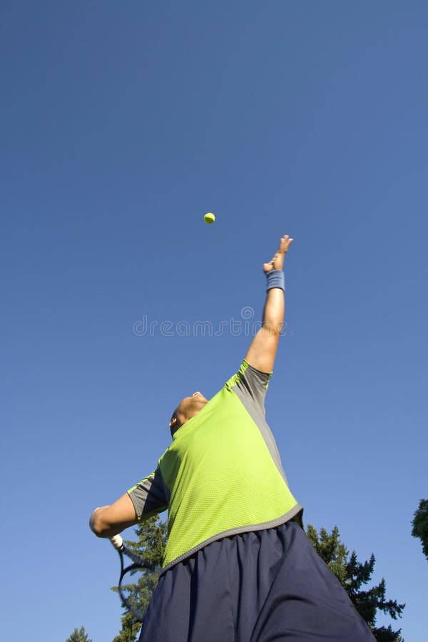 Man on Tennis Court Serving Tennis Ball - Vertical