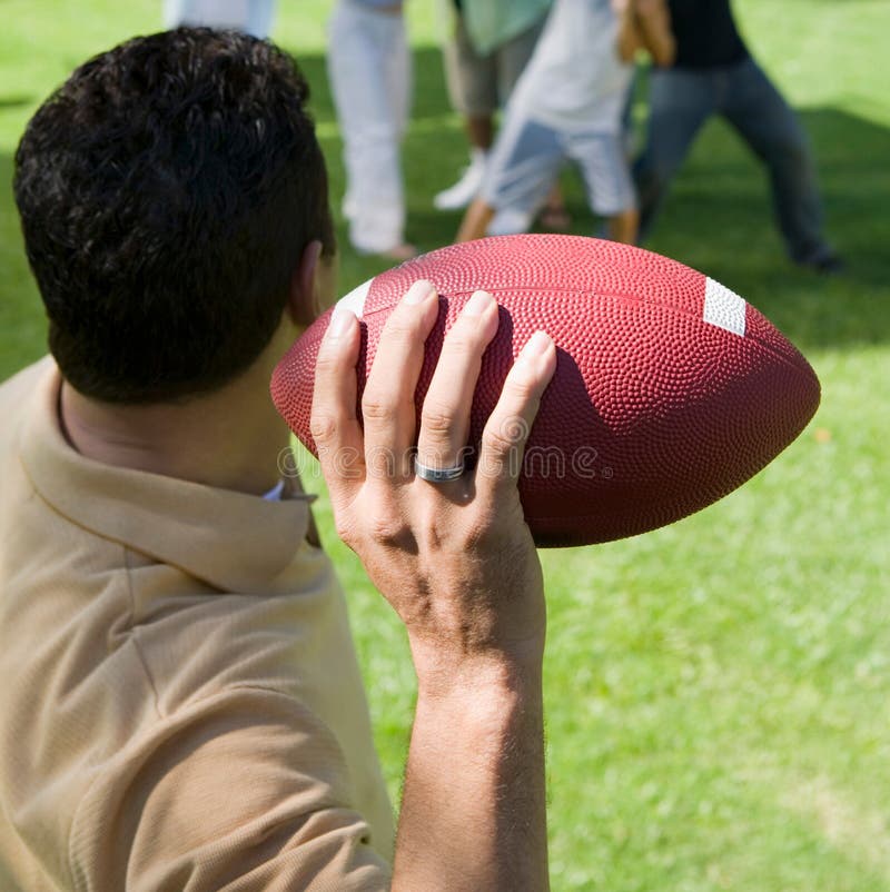 Man Throwing Football To Group of People Back View. Stock Photo Image