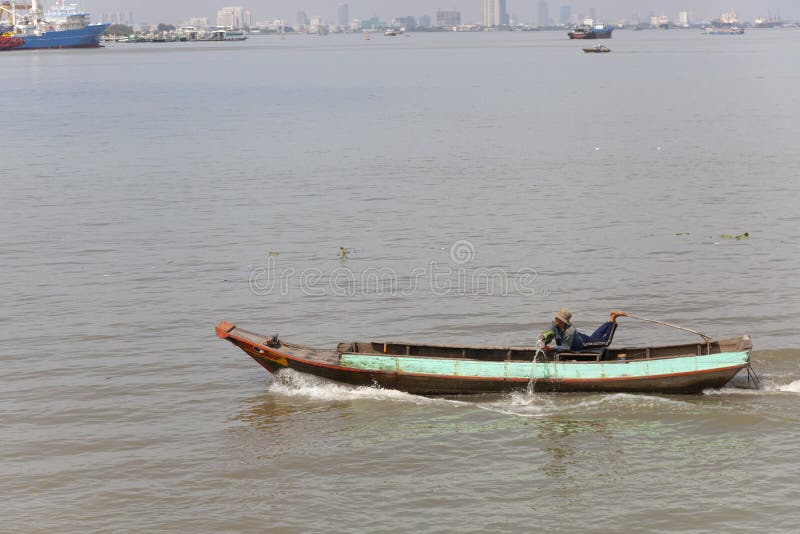Man Throwing Out Water from His Boat on the Saigon River Editorial