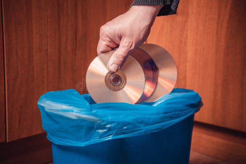 A Man Throws CDs into the Trash Can. Man S Hand with CDs and Trash Can