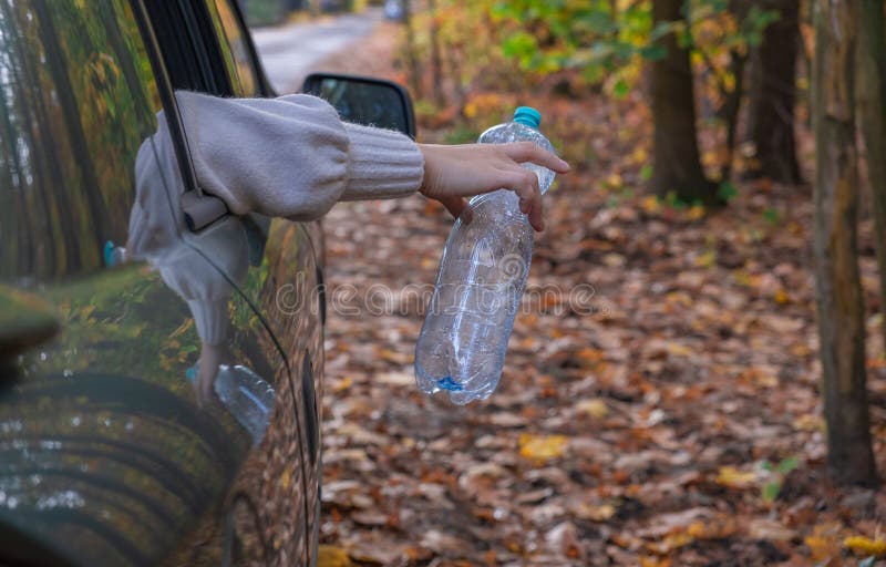 A Man Throws an Empty Plastic Bottle Out of a Car. Stock Photo Image