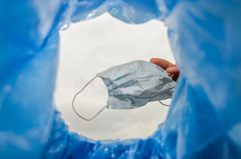 Man Throws a Used Medical Mask into the Trash Can Stock Photo Image
