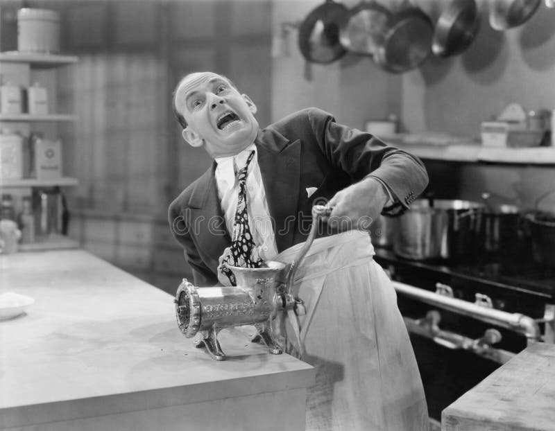 Man with tie stuck in meat grinder