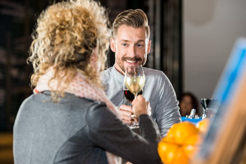 Man Toasting Wine With Friend In Bar stock photo Man Toasting Wine With Friend In Bar stock photo