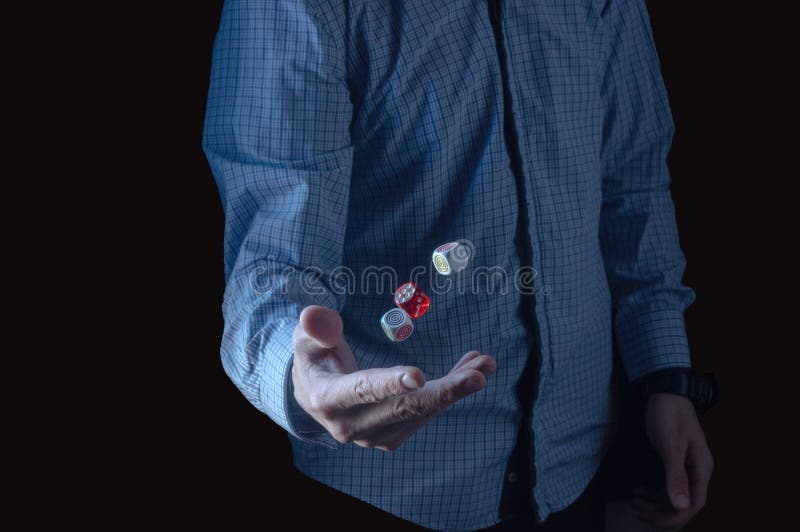 The Man Tosses the Dice. Three Cubes in the Air. a Man in a Plaid Shirt