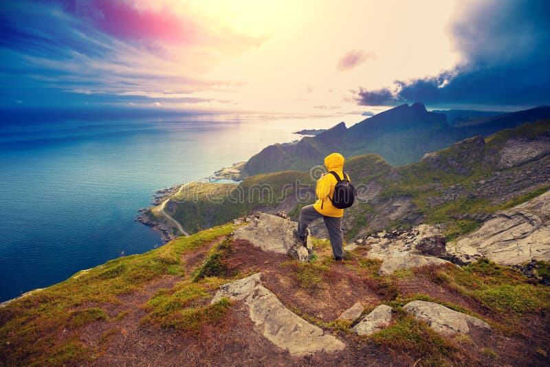 Man tourist standing on a cliff of rock stock photography
