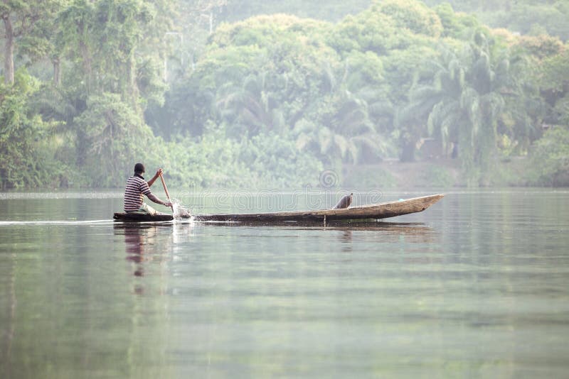 Man in Traditional Boat on Tropical River Volta in Ghana, West A stock image
