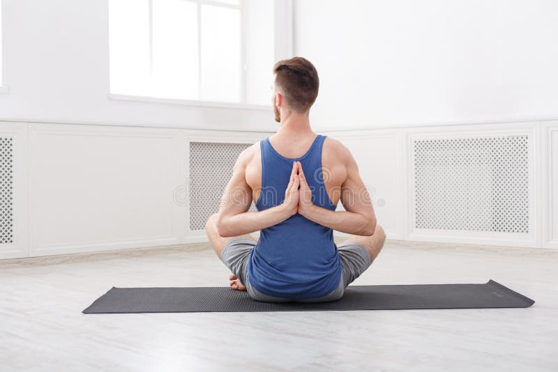 Man training yoga in lotus pose, copy space