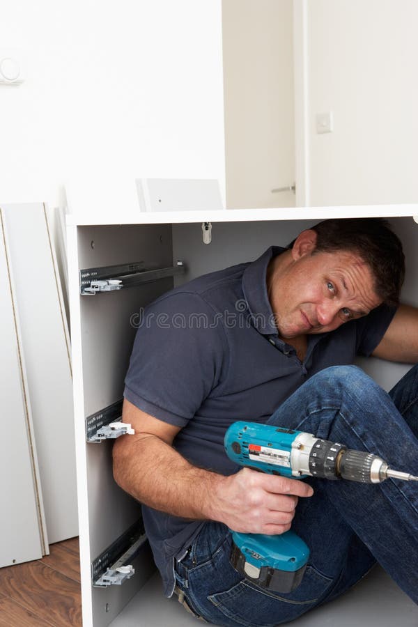 Man Trapped Whilst Assembling Flat Pack Furniture stock photo Man Trapped Whilst Assembling Flat Pack Furniture stock photo