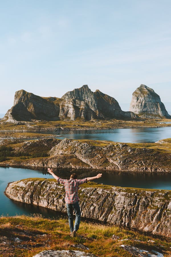 Man traveler raised hands enjoying islands view travel adventure vacations. Healthy lifestyle success motivation Helgeland landscape in Norway stock photo Man traveler raised hands enjoying islands view travel adventure vacations. Healthy lifestyle success motivation Helgeland landscape in Norway stock photo