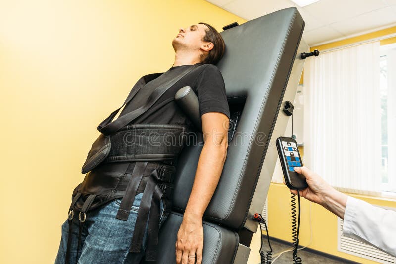 Man on treatment recovery physiotherapy of human spine by stretching with special medical equipment in clinic stock photos Man on treatment recovery physiotherapy of human spine by stretching with special medical equipment in clinic stock photos