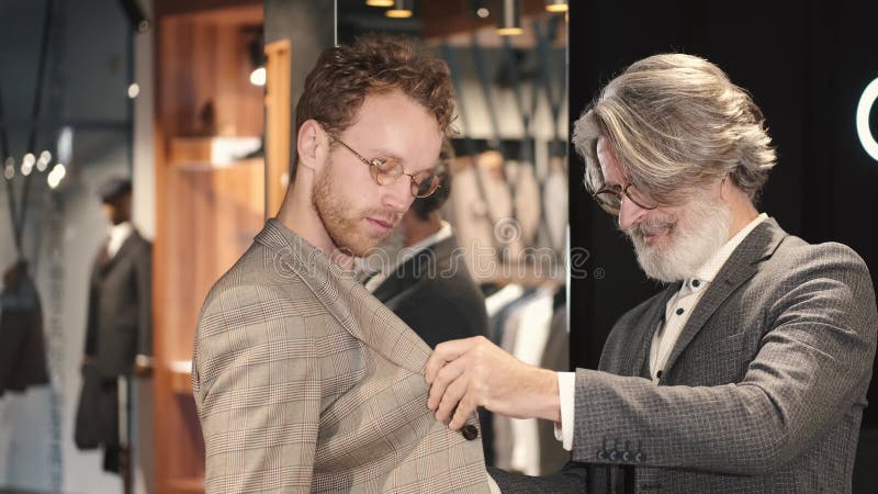 Man Trying Business Suit on with Consultant at Men Clothing Store Stock ...