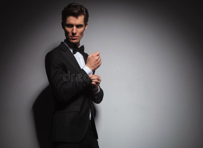 Man In Tuxedo Arranging His Sleeve Looks Back Over Shoulder Stock Image ...