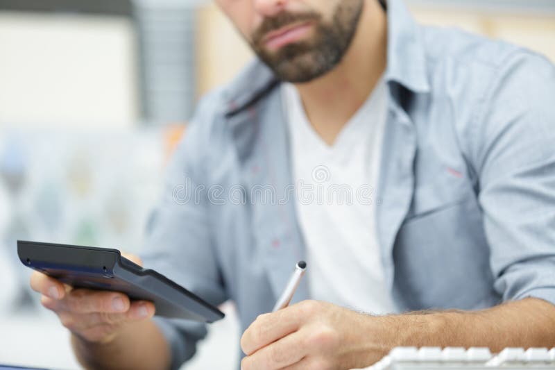 Man using calculator in office stock photography