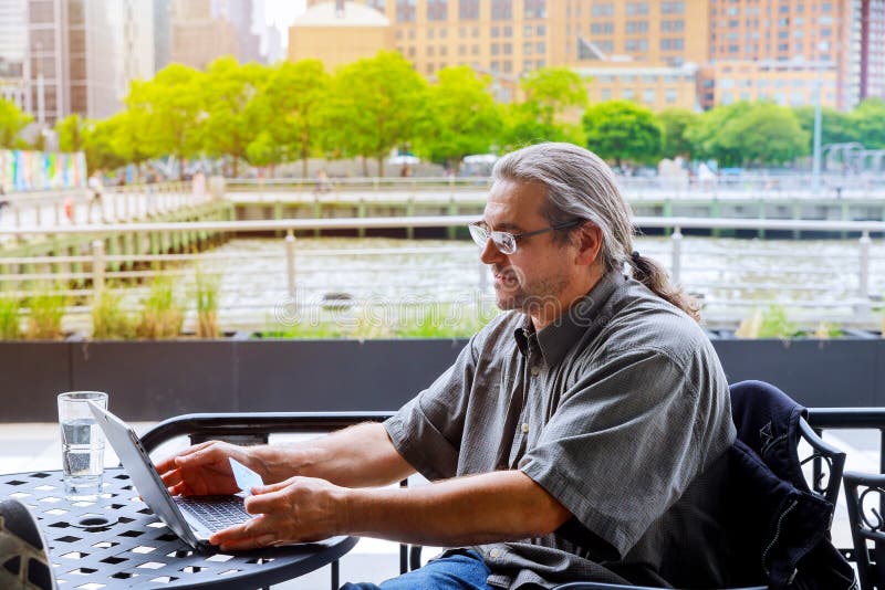 Man Using Credit Card And Laptop Shopping Online Outdoor Stock