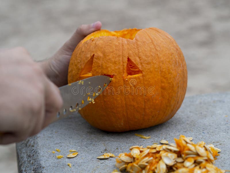 Man Using a Knife Carving a Pumpkin for a Halloween Lantern Stock Image