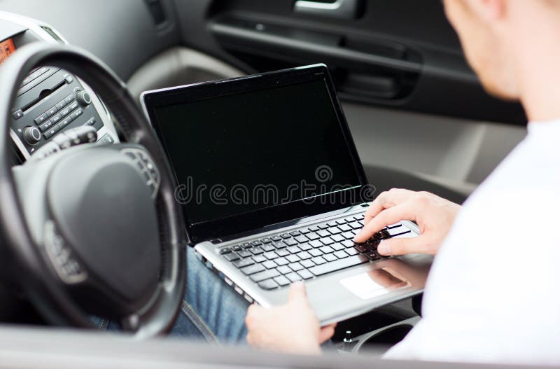 Man using laptop computer in car royalty free stock image