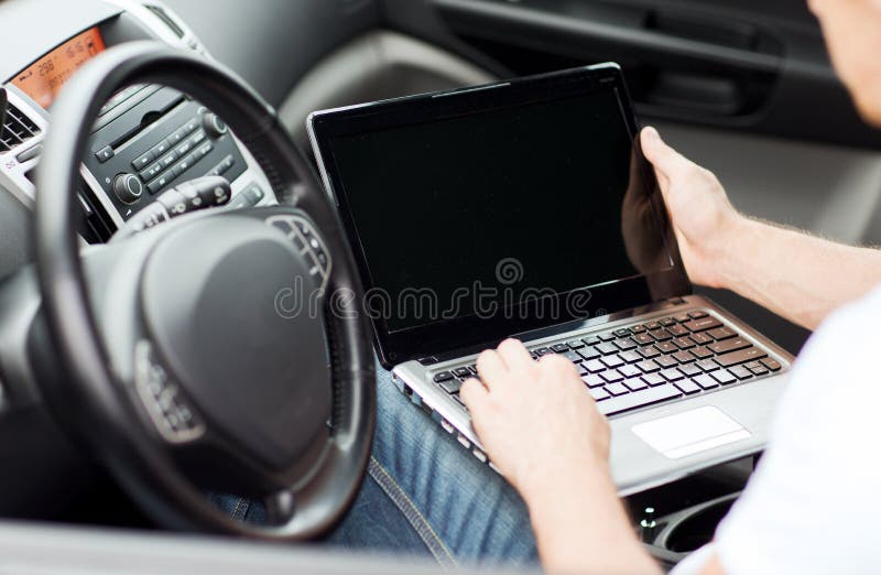Man using laptop computer in car stock photo