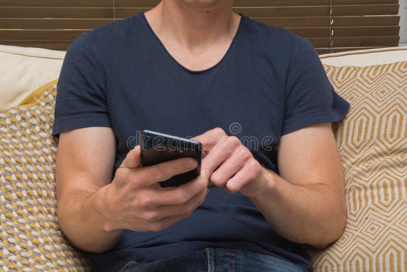 Man Using a Mobile Phone at Home on the Sofa Stock Image Image of