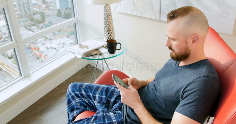 Man using mobile phone in living room 4k