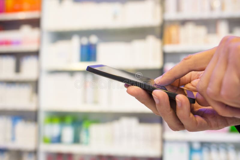 Man using a mobile phone in Pharmacy stock images Man using a mobile phone in Pharmacy stock images
