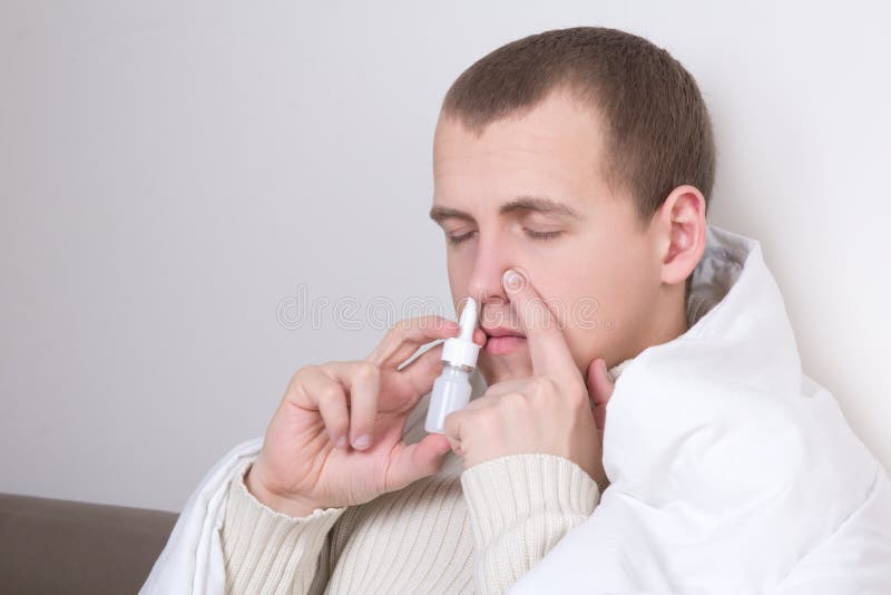 Man Using Nasal Spray in His Living Room Stock Photo Image of male