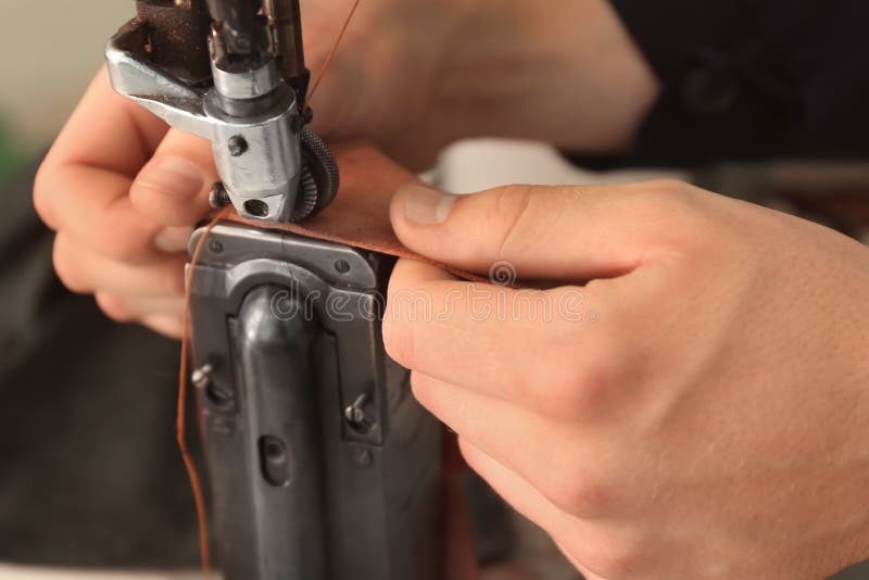 Hombre de coser máquina en piel taller, detallado.
