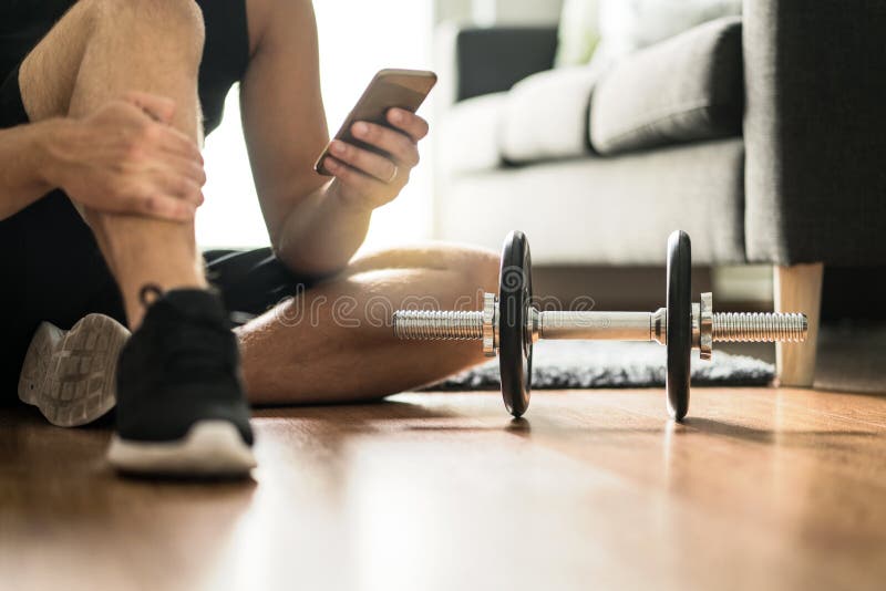 Man using smartphone during workout at home royalty free stock photo