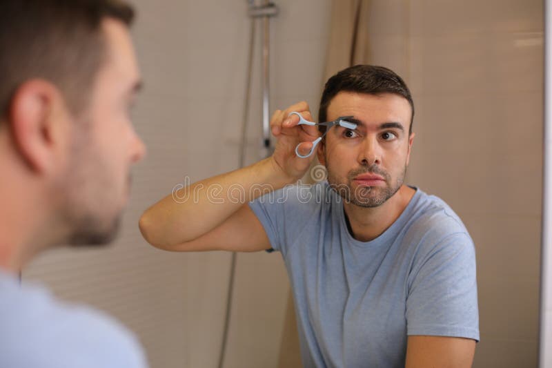 Man Using Special Scissors Than Include a Comb To Cut His Eyebrows