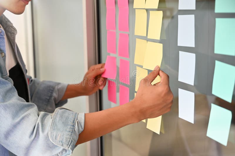 Man using sticky note paper on windows office notice memo reminder stock photo Man using sticky note paper on windows office notice memo reminder stock photo
