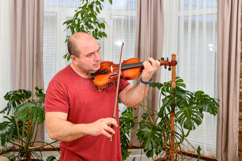 A Man with a Violin in His Hand Plays Pieces of Music Stock Photo
