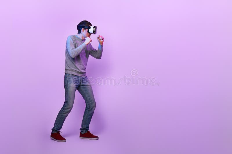 Man with Virtual Reality Headset is Playing Game and Fighting. Stock