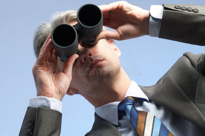 One businessman is looking trough field-glasses. One businessman is looking trough field-glasses