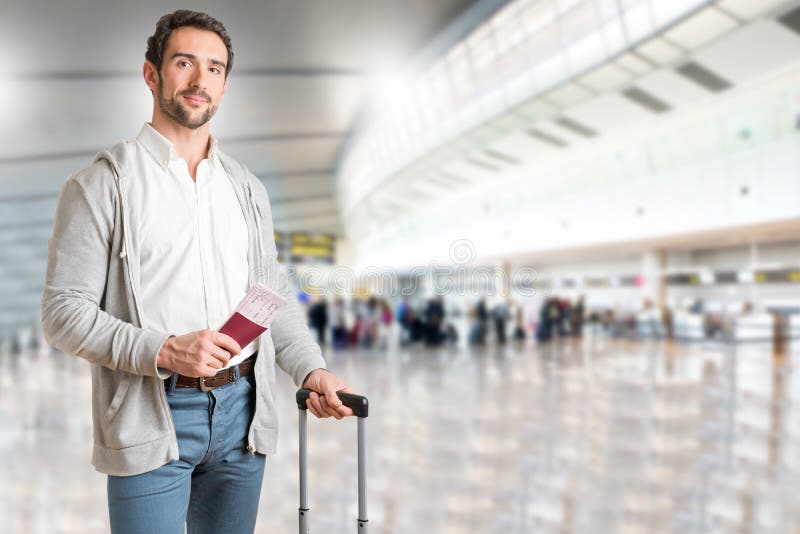 L'uomo in attesa in un aeroporto, in possesso di un biglietto, in un aeroporto.