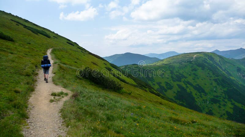 Man walking in hills on path with big bag in tatra mountains