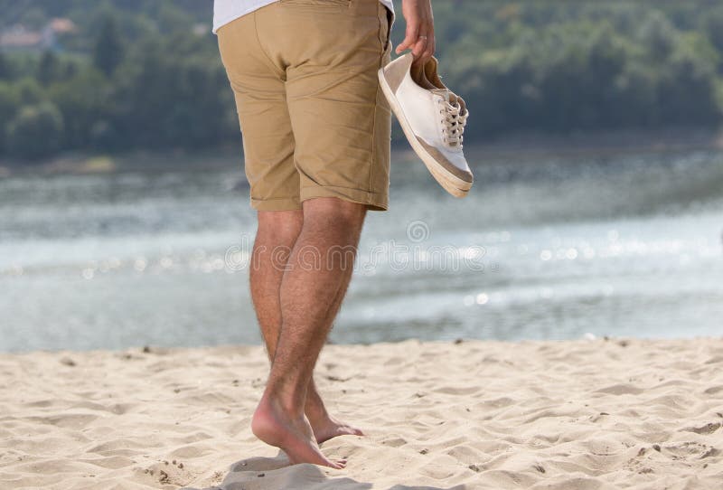 Man Walking on Sand with Shoes in Hand Stock Photo - Image of shore,  leisure: 124974332