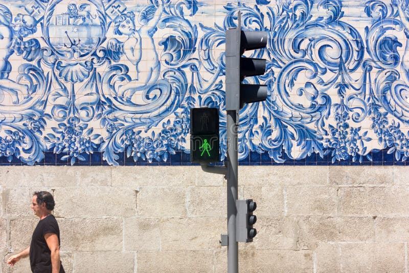 Man walks past the blue and white tiles azulejo on Carmo Church in Porto, Portugal royalty free stock photography Man walks past the blue and white tiles azulejo on Carmo Church in Porto, Portugal royalty free stock photography