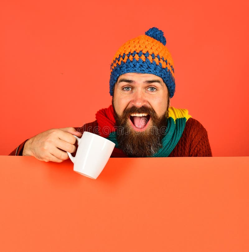 Man in Warm Hat Holds White Cup on Orange Background Stock Photo ...
