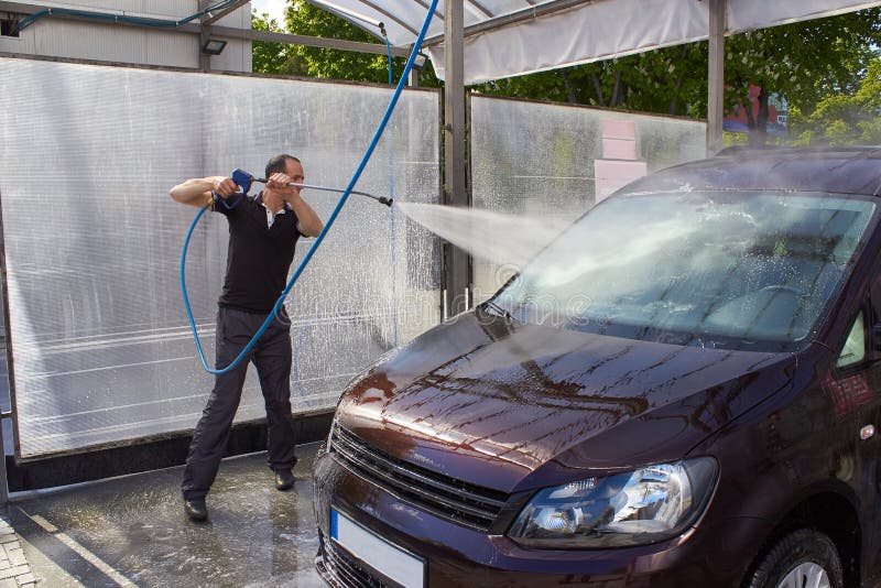 Man Washes the Windshield of a Car,man Washes the Car with High Water
