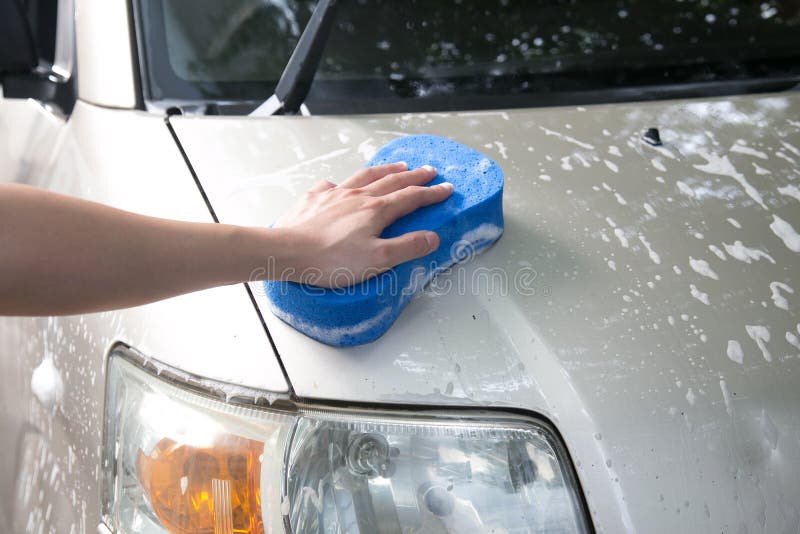 Man washing  car with blue sponge