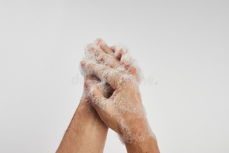 Man washing dirty hands with soap, close-up. Soapy male hands isolated on white background with copy space.  Hand washing medical procedure step. Personal hygiene