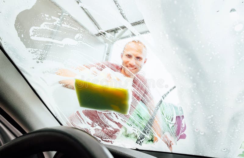 Man washing his car windshield window inside the car camera view stock photography Man washing his car windshield window inside the car camera view stock photography