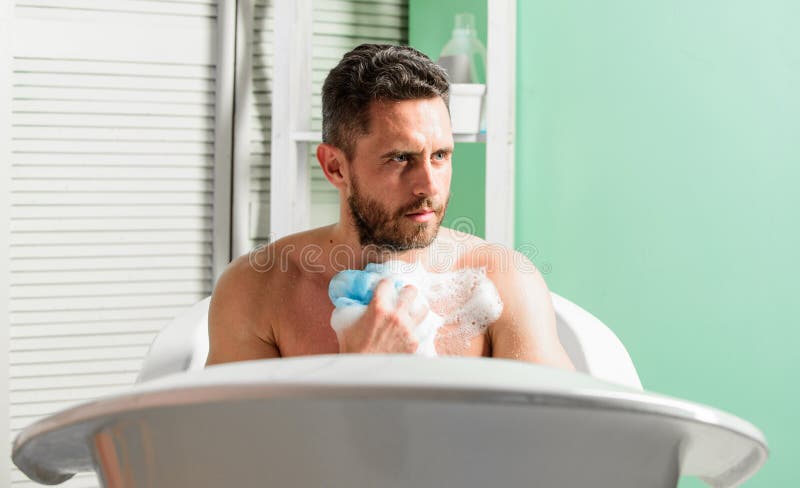 Man Wash Muscular Body With Foam Sponge Macho Naked In Bathtub Sex And Relaxation Concept