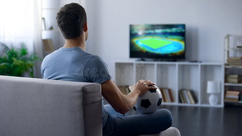 Man watching game on tv at home supporting one of soccer team, match result stock photo Man watching game on tv at home supporting one of soccer team, match result stock photo