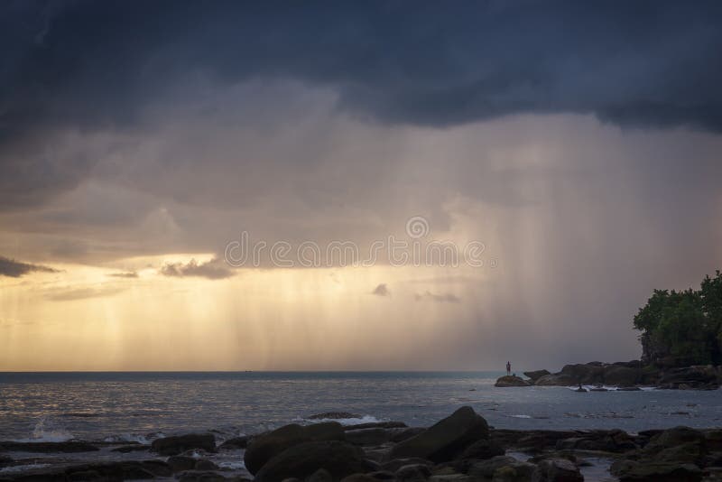 Man watching rainstrom out at sea